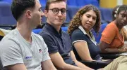 Estudiantes internacionales sentados en el auditorio mientras escuchan las palabras del rector